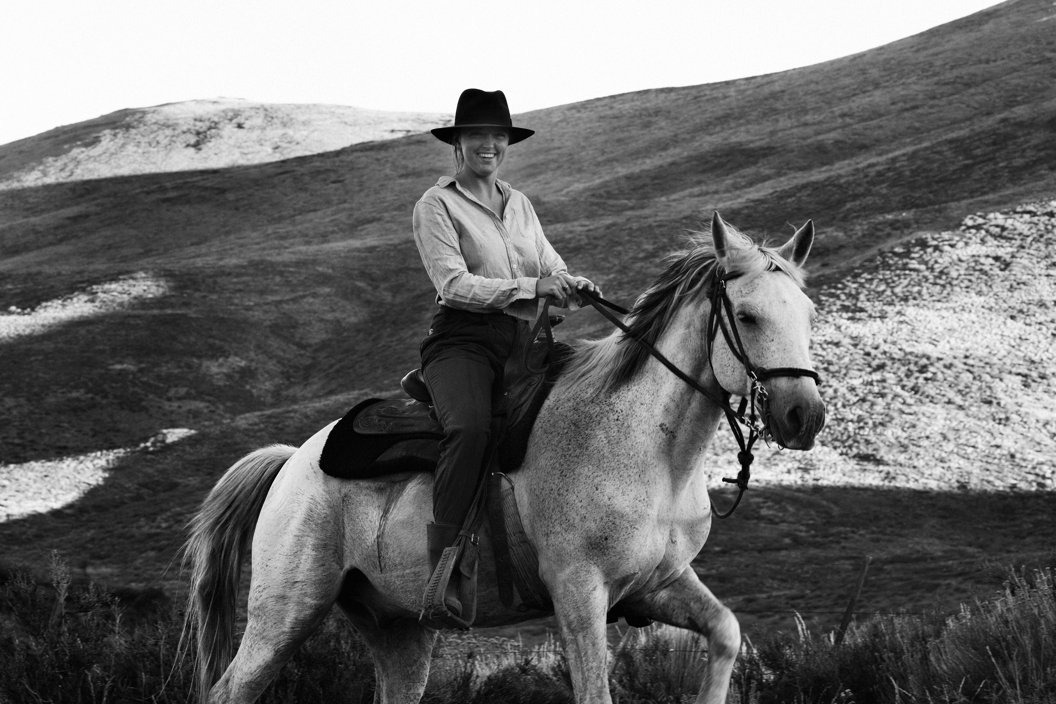 Black and white photo of woman riding criollo horse at Estancia Ranquilco in Patagonia Argentina