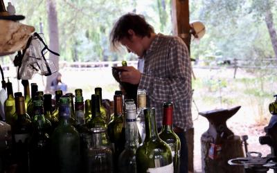 Man cleaning empty Argentine Malbec bottles to reuse and make into glasses