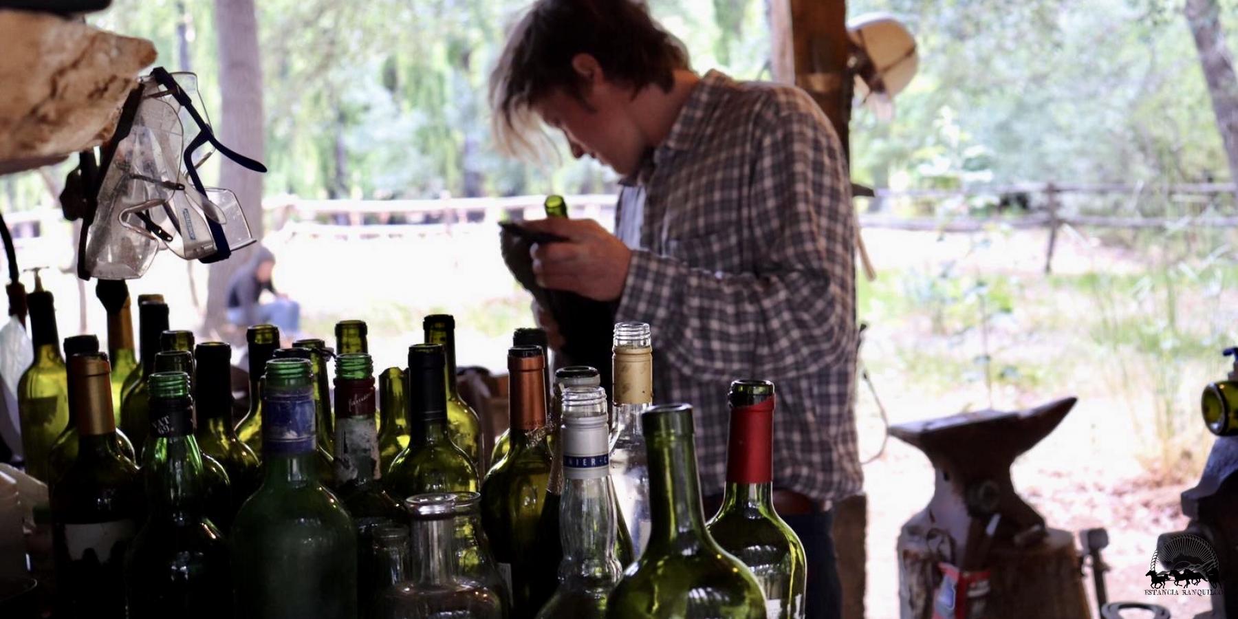 Man cleaning empty Argentine Malbec bottles to reuse and make into glasses