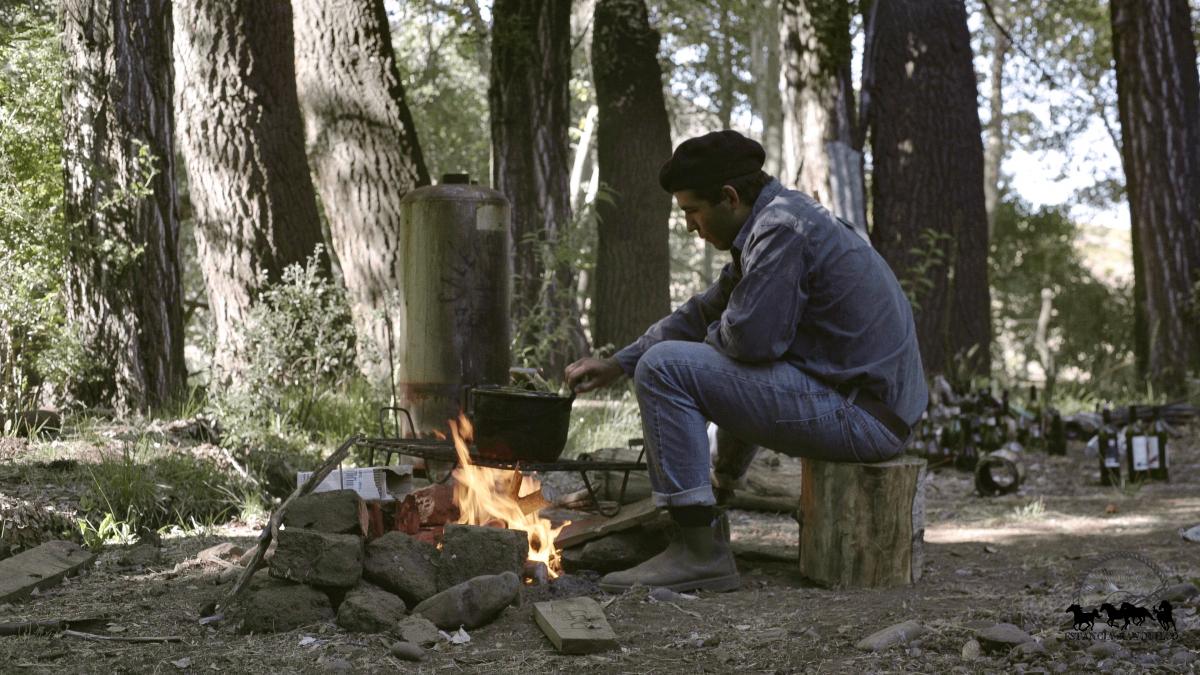 Intern cooking over a fire at Estancia Ranquilco in Patagonia Argentina