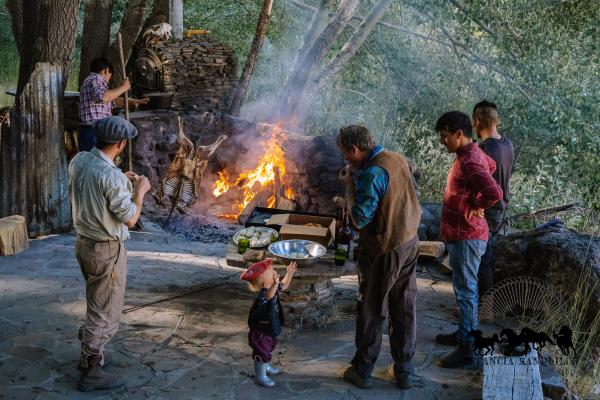 People standing around a roasting goat asado at Estancia Ranquilco